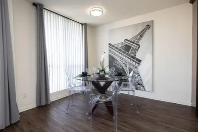 a dining room with a table and a picture of the eiffel tower at Skyline Views 1-Bedroom with Balcony and Pool in Los Angeles