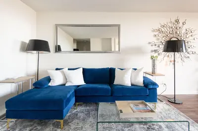 a blue couch in a living room with a mirror at Skyline Views 1-Bedroom with Balcony and Pool in Los Angeles