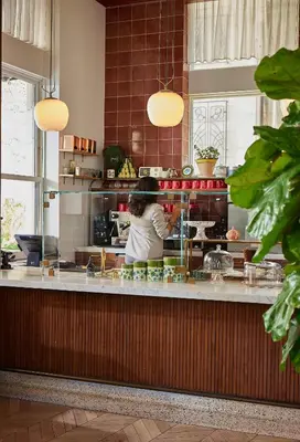 a woman standing behind a counter in a kitchen at The Hoxton, Downtown LA in Los Angeles