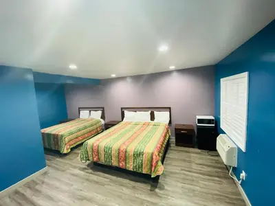 a hotel room with two beds and blue walls at Cozy motel in Lynwood