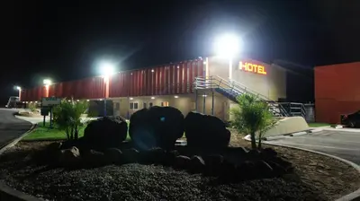 a building with a hino sign at night at Apple Valley Hotel & Lodge in Apple Valley