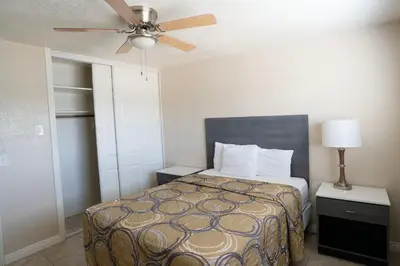 a bedroom with a bed and a ceiling fan at Apple Valley Hotel & Lodge in Apple Valley