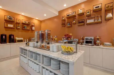 a kitchen with a counter with plates and fruit on it at Hilton Garden Inn Anaheim Resort in Anaheim