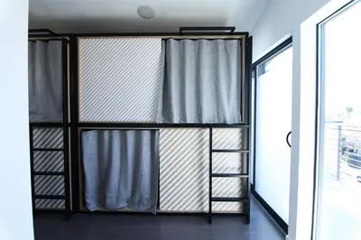 a room with a bed with curtains and a window at Haven Coliving in Los Angeles