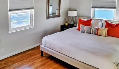 a bedroom with a bed with orange and white pillows at Top Location Walk to Dining, Shops & Near Beach CC E in Culver City