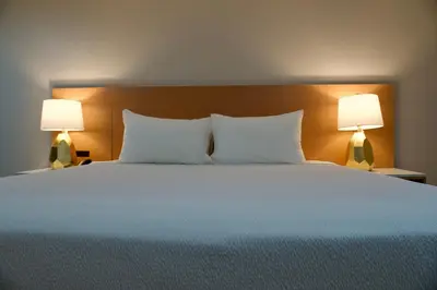 a bedroom with a large bed with two lamps at Highland Inn - San Bernardino in Highland