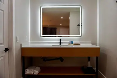 a bathroom with a sink with a large mirror at Highland Inn - San Bernardino in Highland