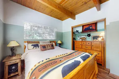 a bedroom with a large bed and a wooden dresser at House of the Rising Sun in Lake Arrowhead