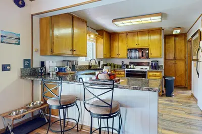 a kitchen with wooden cabinets and a island with bar stools at House of the Rising Sun in Lake Arrowhead
