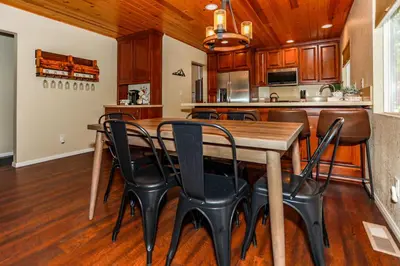 a kitchen and dining room with a wooden table and chairs at Bohemia Big Bear-1926 by Big Bear Vacations in Big Bear Lake