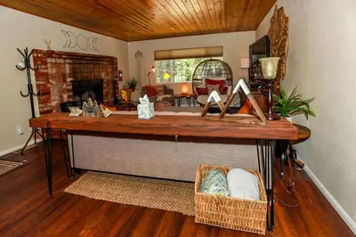 a table in a living room with a fireplace at Bohemia Big Bear-1926 by Big Bear Vacations in Big Bear Lake