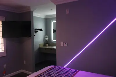 a purple bedroom with a purple wall with a neon light at ERTH INN by AGA Maywood in Maywood