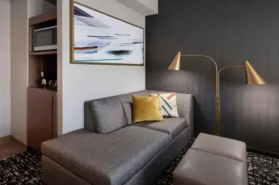 a living room with a couch and a lamp at Hyatt Place LAX/Century BLVD in Los Angeles