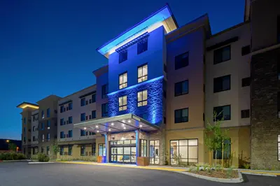 an apartment building with a blue facade at night at Holiday Inn Express & Suites - Valencia - Santa Clarita by IHG in Valencia