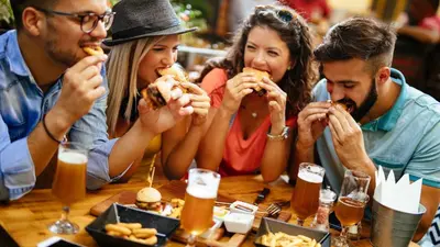 a group of people sitting at a table eating food at Holiday Inn Express & Suites - Valencia - Santa Clarita by IHG in Valencia