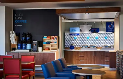 a coffee shop with blue chairs and a table at Holiday Inn Express & Suites - Valencia - Santa Clarita by IHG in Valencia