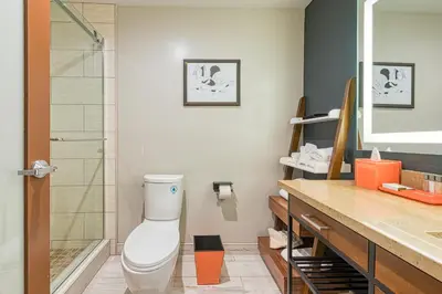 a bathroom with a toilet and a glass shower at Hotel Lexen Newhall & Santa Clarita - Near Six Flags Magic Mountain in Santa Clarita