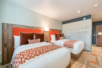 a room with two beds and a large screen at Hotel Lexen Newhall & Santa Clarita - Near Six Flags Magic Mountain in Santa Clarita