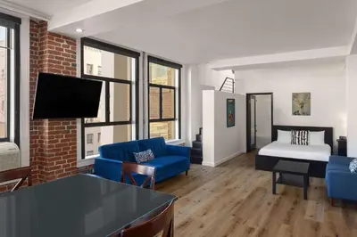 a living room with two blue chairs and a couch at The Haas, Trademark Collection by Wyndham in Los Angeles