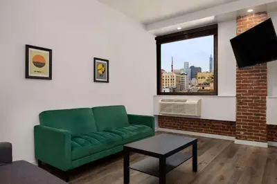 a living room with a green couch and a window at The Haas, Trademark Collection by Wyndham in Los Angeles