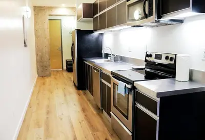 a kitchen with stainless steel appliances and a wooden floor at The Haas, Trademark Collection by Wyndham in Los Angeles