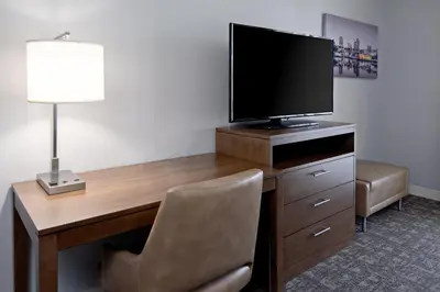 a room with a desk with a television and a chair at Staybridge Suites - Long Beach Airport by IHG in Long Beach