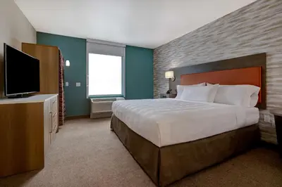 a bedroom with a large bed and a flat screen tv at Home2 Suites By Hilton Barstow, Ca in Barstow