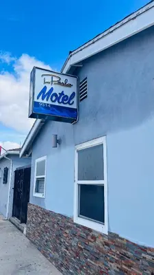 a motel sign on the side of a building at La Perla motel in South Gate