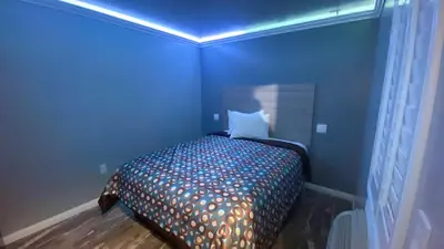 a blue bedroom with a bed with a blue ceiling at La Perla motel in South Gate