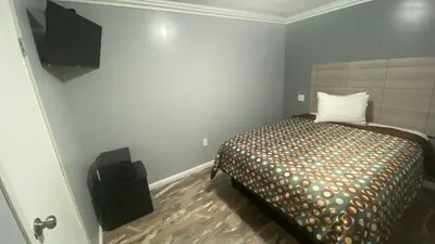 a small bedroom with a bed and a speaker at La Perla motel in South Gate
