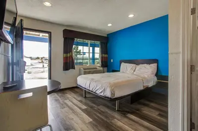 a bedroom with a bed and a blue wall at High Desert Inn in Hesperia