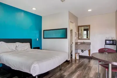 a bedroom with a large bed and a blue wall at High Desert Inn in Hesperia