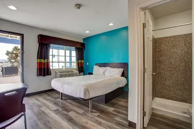 a bedroom with a bed and a blue wall at High Desert Inn in Hesperia