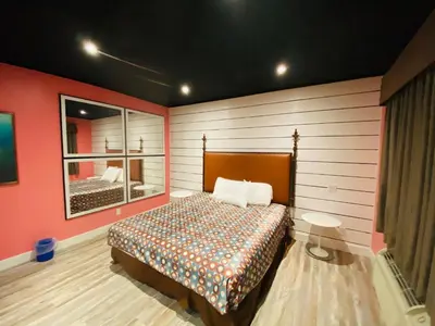 a bedroom with a bed with red walls and a window at Casa Valentine Inn - Los Angeles in Los Angeles