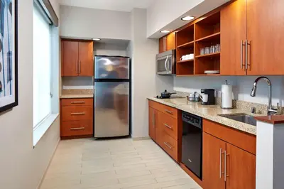 a kitchen with wooden cabinets and a stainless steel refrigerator at Hyatt Place Los Angeles / LAX / El Segundo in El Segundo