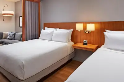 a hotel room with two beds and a couch at Hyatt Place Los Angeles / LAX / El Segundo in El Segundo
