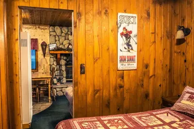 a room with wooden walls and a room with a bed at Eagle's Nest in Big Bear Lake