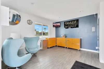 a office with a blue chair and a desk and a tv at Tradewinds Motel in Lakewood