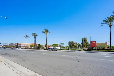 an empty street with palm trees on the side of the road at Tradewinds Motel in Lakewood