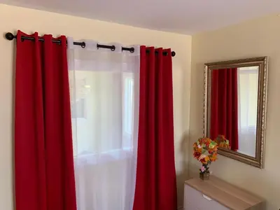 a room with red curtains and a mirror at LAX guest house in Inglewood