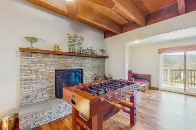 a living room with a foosball table in front of a fireplace at Lake View Magic in Crestline