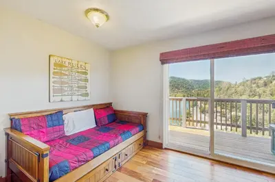 a bedroom with a bed and a balcony at Lake View Magic in Crestline