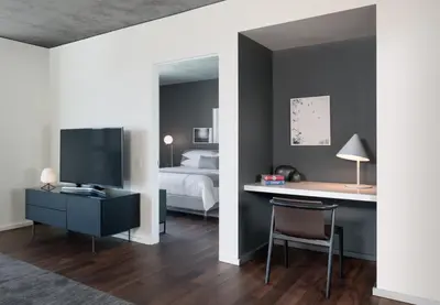 a bedroom with a bed and a desk with a television at AKA West Hollywood in Los Angeles