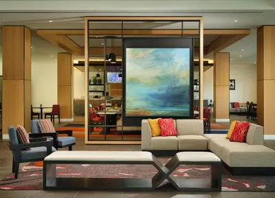 a living room with a couch and a painting at Hyatt House LA - University Medical Center in Los Angeles