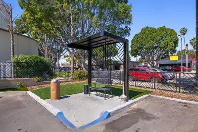 a bus stop with a bench in a parking lot at Hyland Inn near Pasadena Civic Center in Pasadena