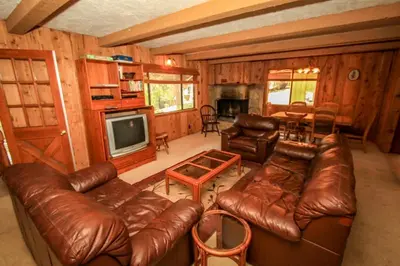 a living room with leather couches and a television at A Big Olympic Getaway apts in Big Bear Lake