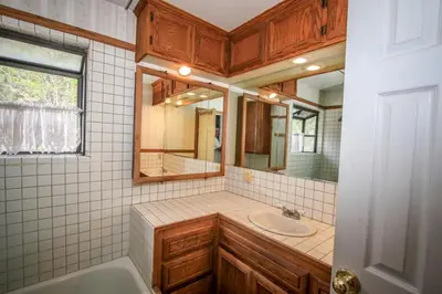 a bathroom with a tub and a sink and a mirror at A Big Olympic Getaway apts in Big Bear Lake