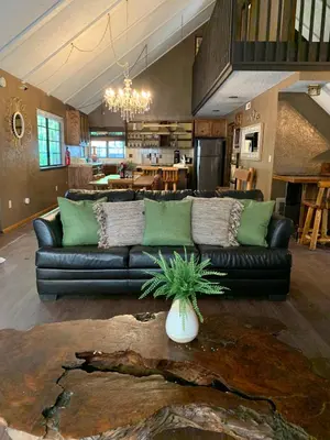 a living room with a black couch and a table at Grey Squirrel Resort in Big Bear Lake