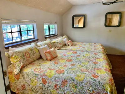 a bedroom with a bed and a couch and windows at Grey Squirrel Resort in Big Bear Lake