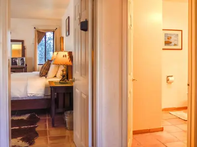 a bedroom with a bed and a table with a lamp at Topanga Canyon Inn Bed and Breakfast in Topanga